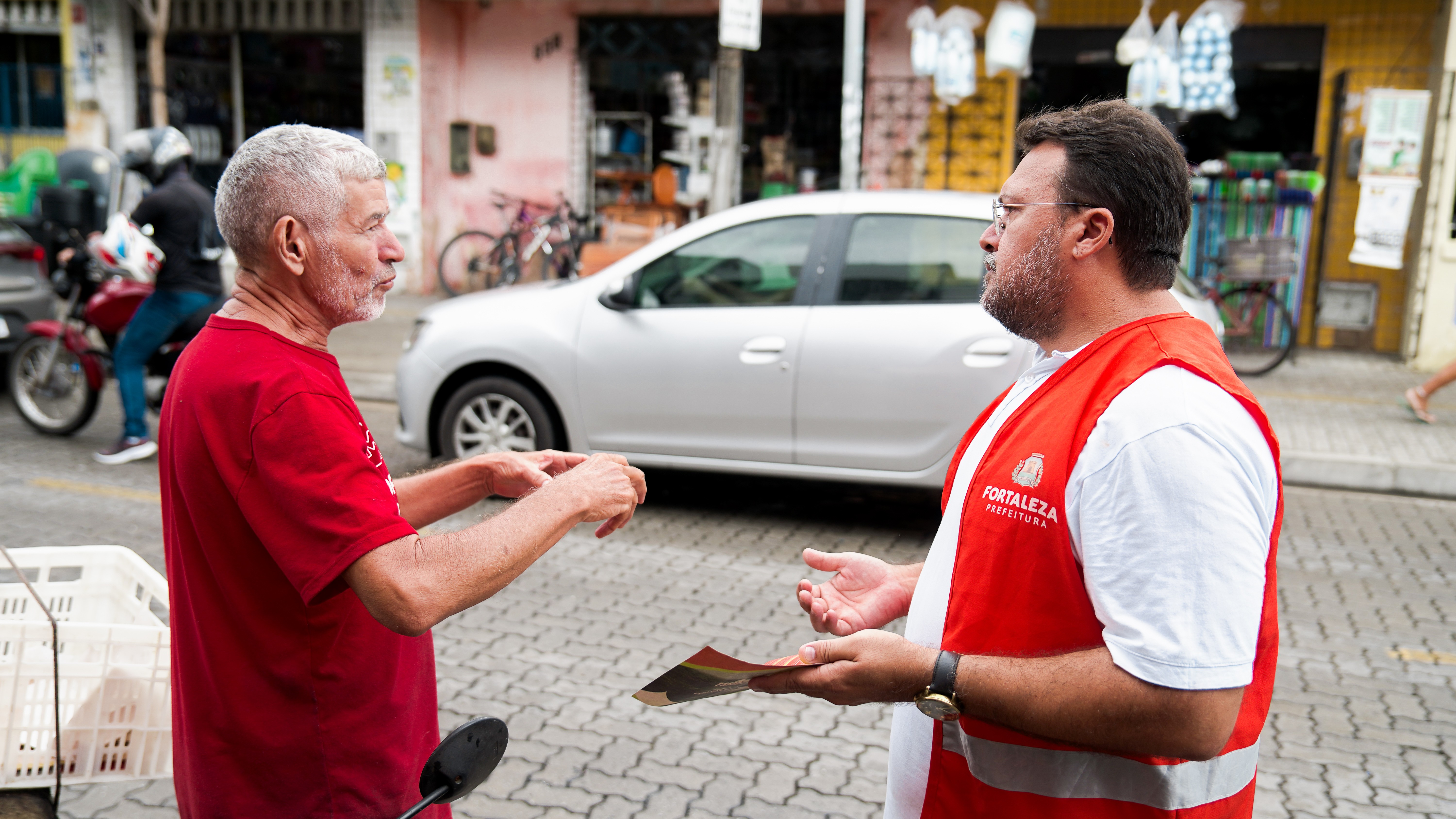 agente de cidadania Dimas conversando com um senhor na rua
